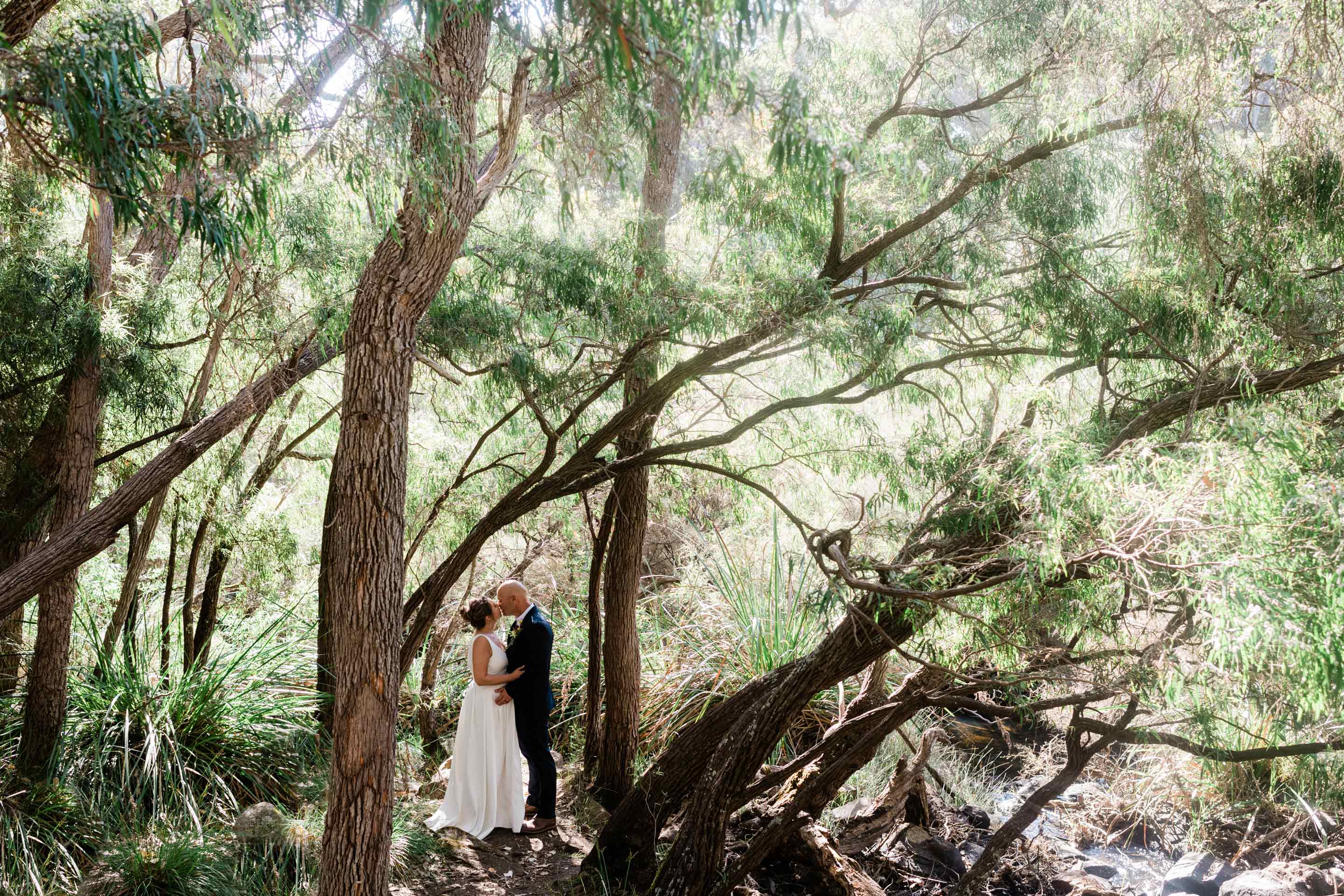 Margaret River elopement locations guide, couple kissing in native paperbark forest at the Margaret River waterfall, photographed by John Rice