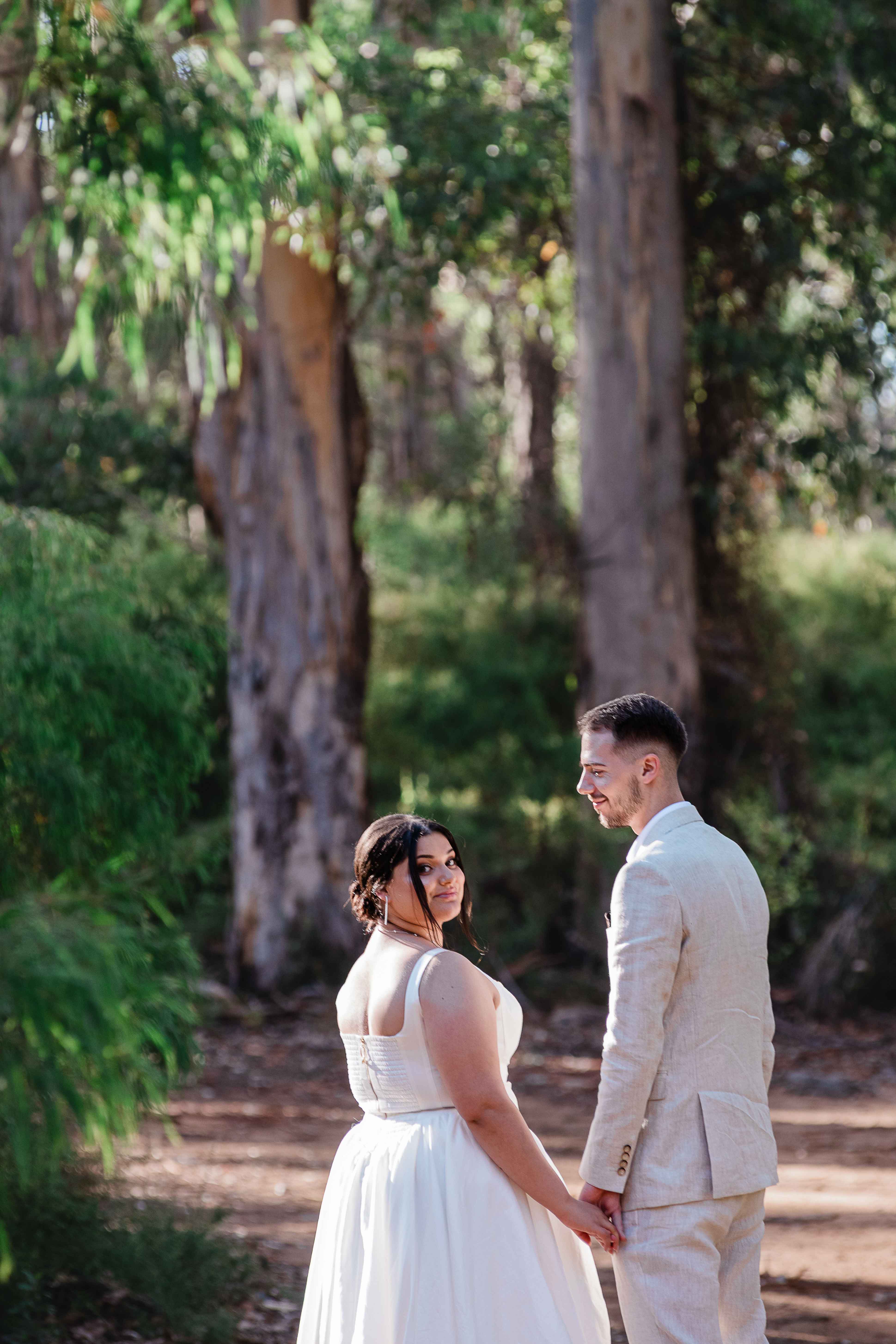 bride groom hold hands looking back at camera at remote boranup 4wd access location