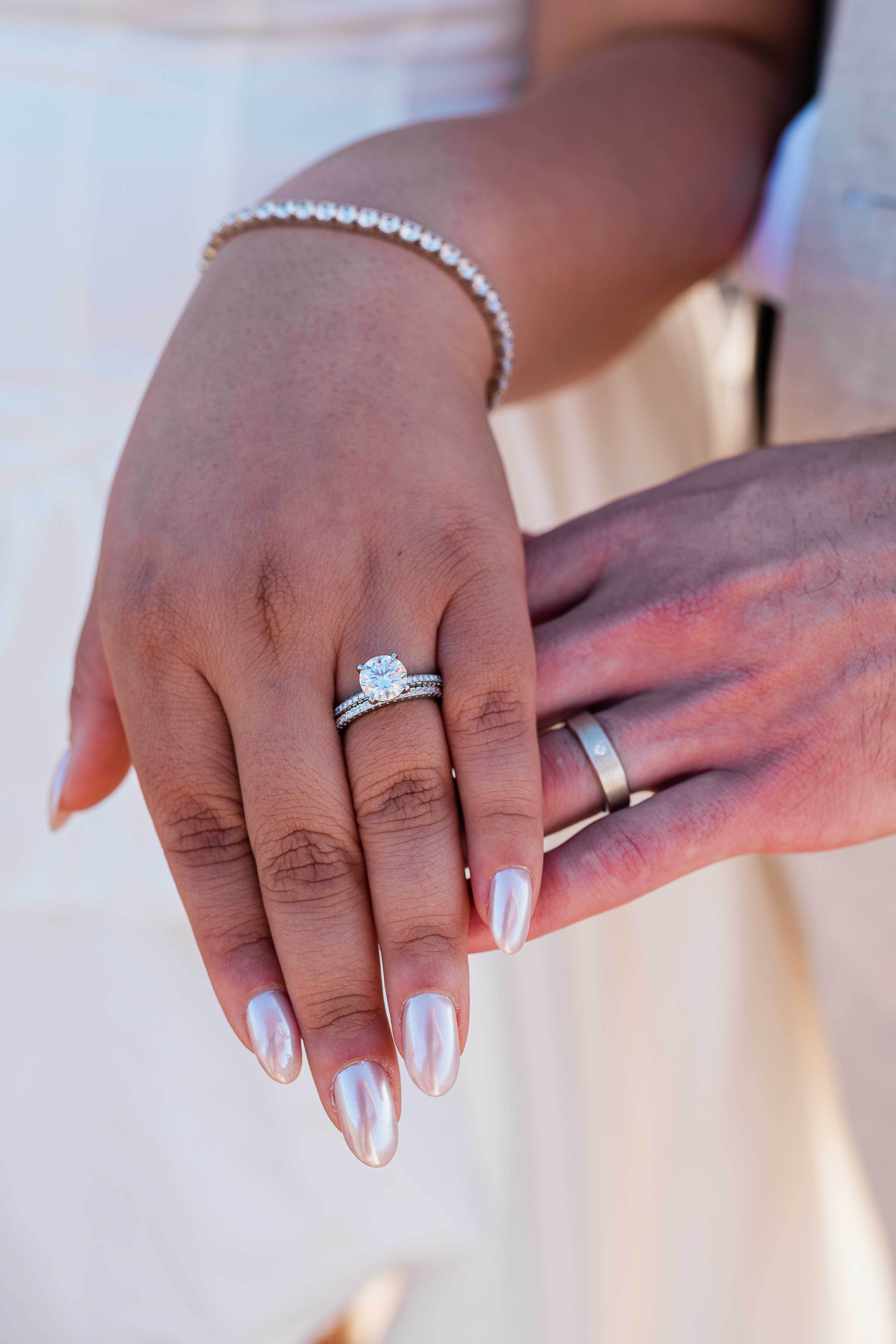 close up of bride and grooms hands displaying their beautiful wedding rings
