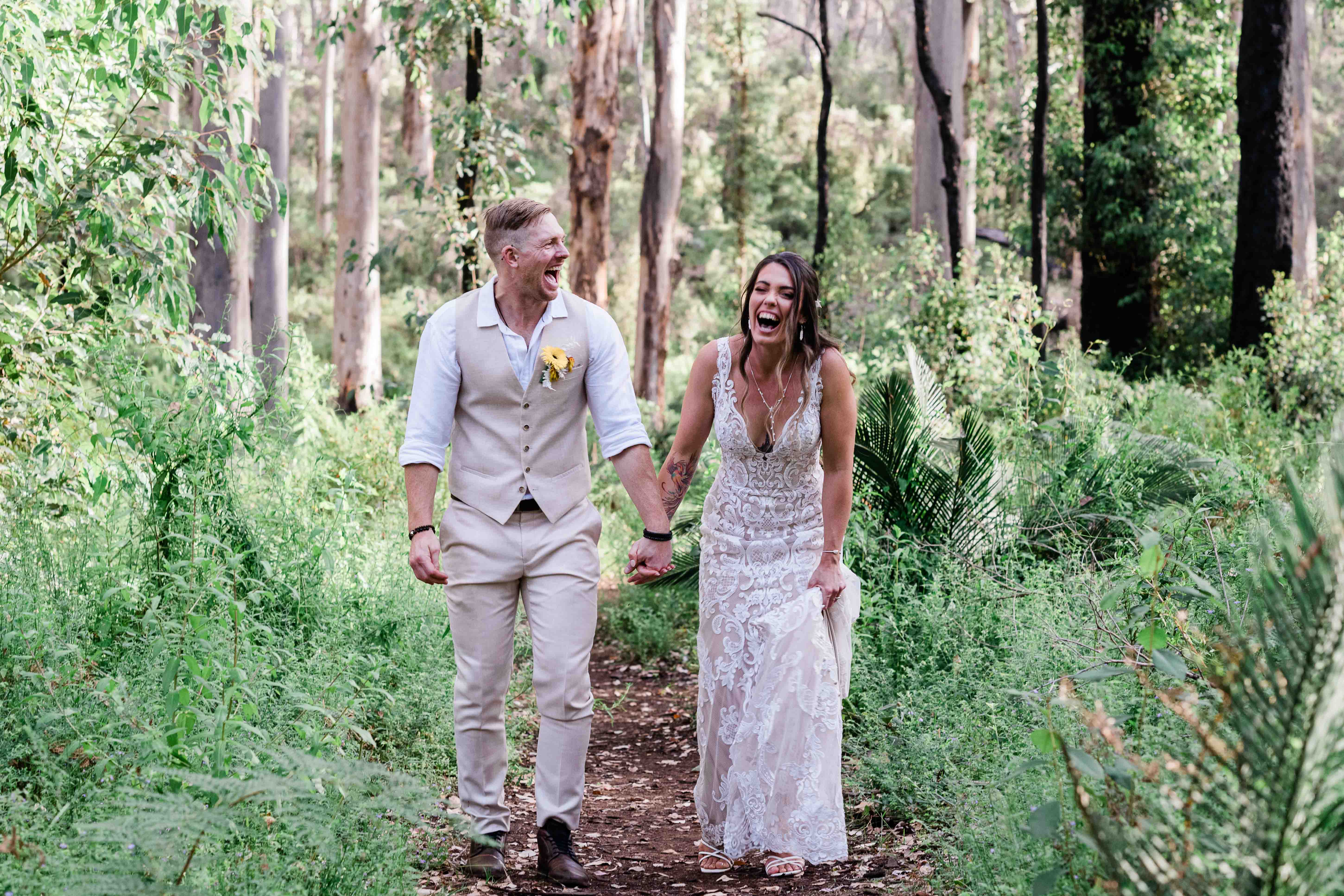 Couple walking and laughing through Boranup Forest karri trees Margaret River elopement photography by John Rice.