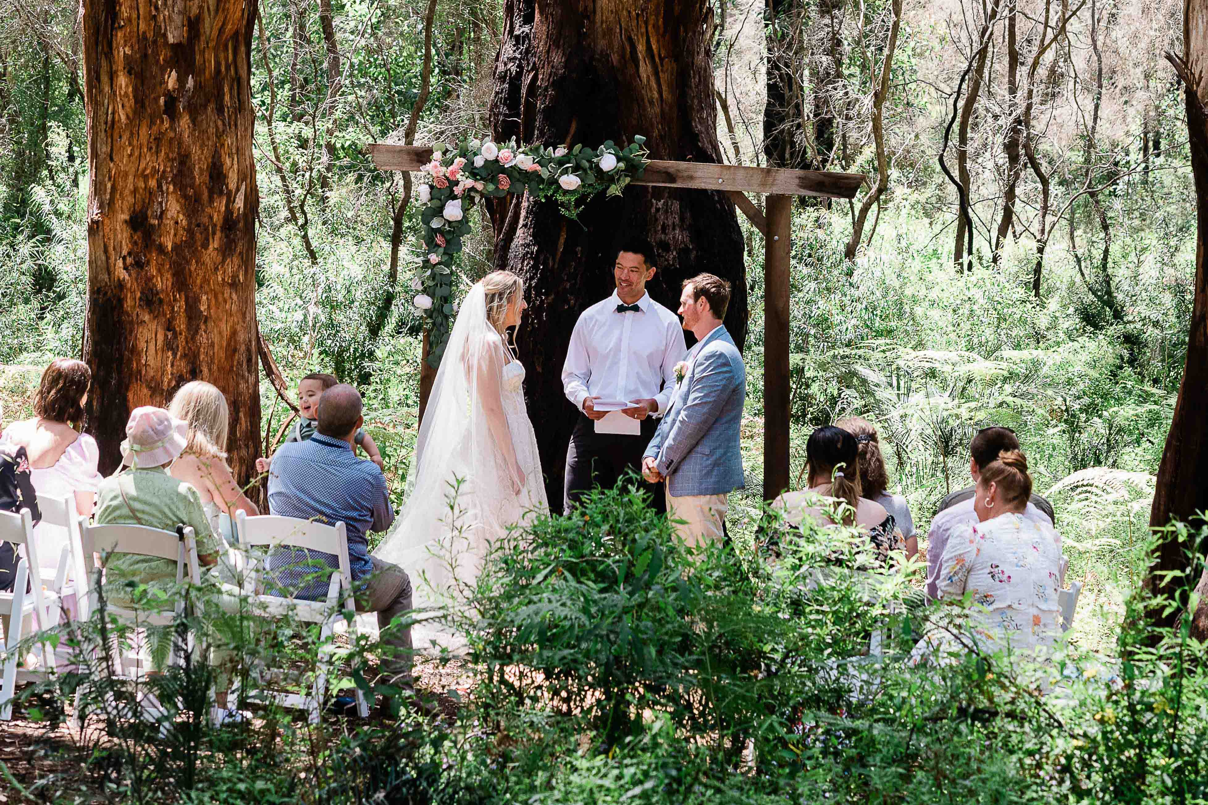 Intimate wedding ceremony in Boranup Forest with small group of guests and floral arch Margaret River planned and photographed by John Rice.