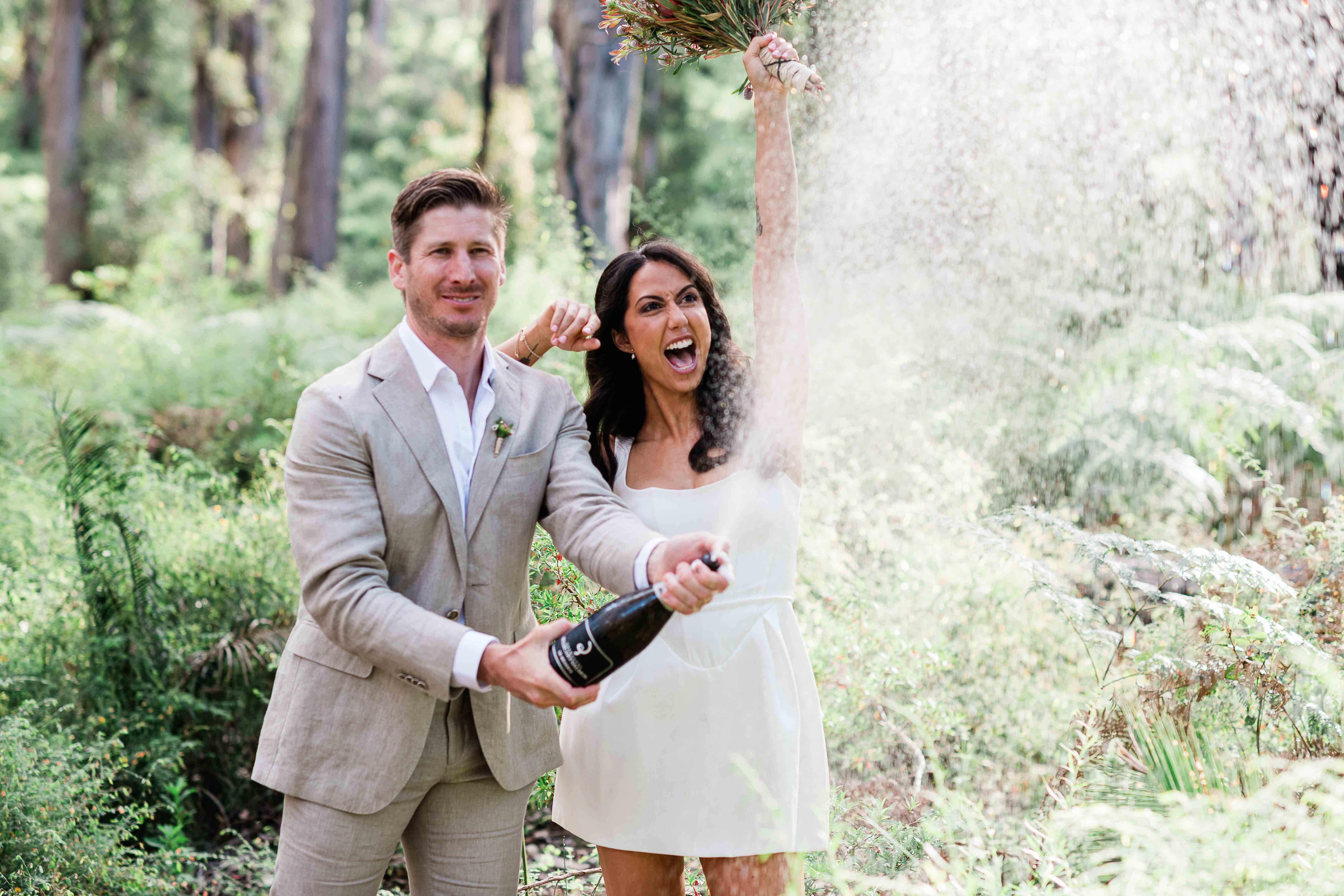 Couple celebrating with champagne at La Foret Enchantee accommodation Margaret River elopement photography by John Rice.