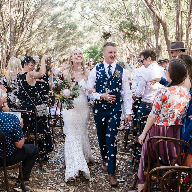 couple walk through confetti at a forest micro-wedding near Margaret River